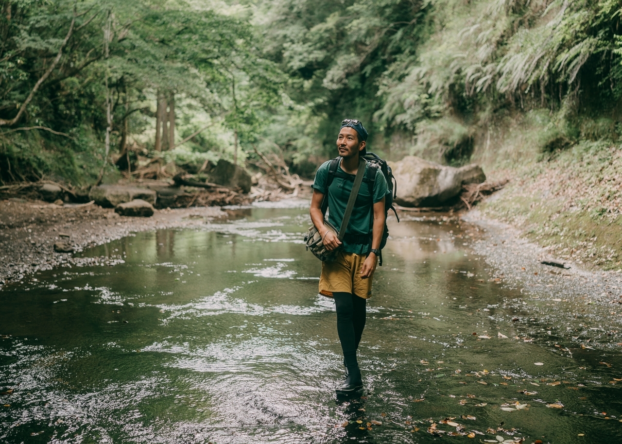 Man hiking through creek in the forest